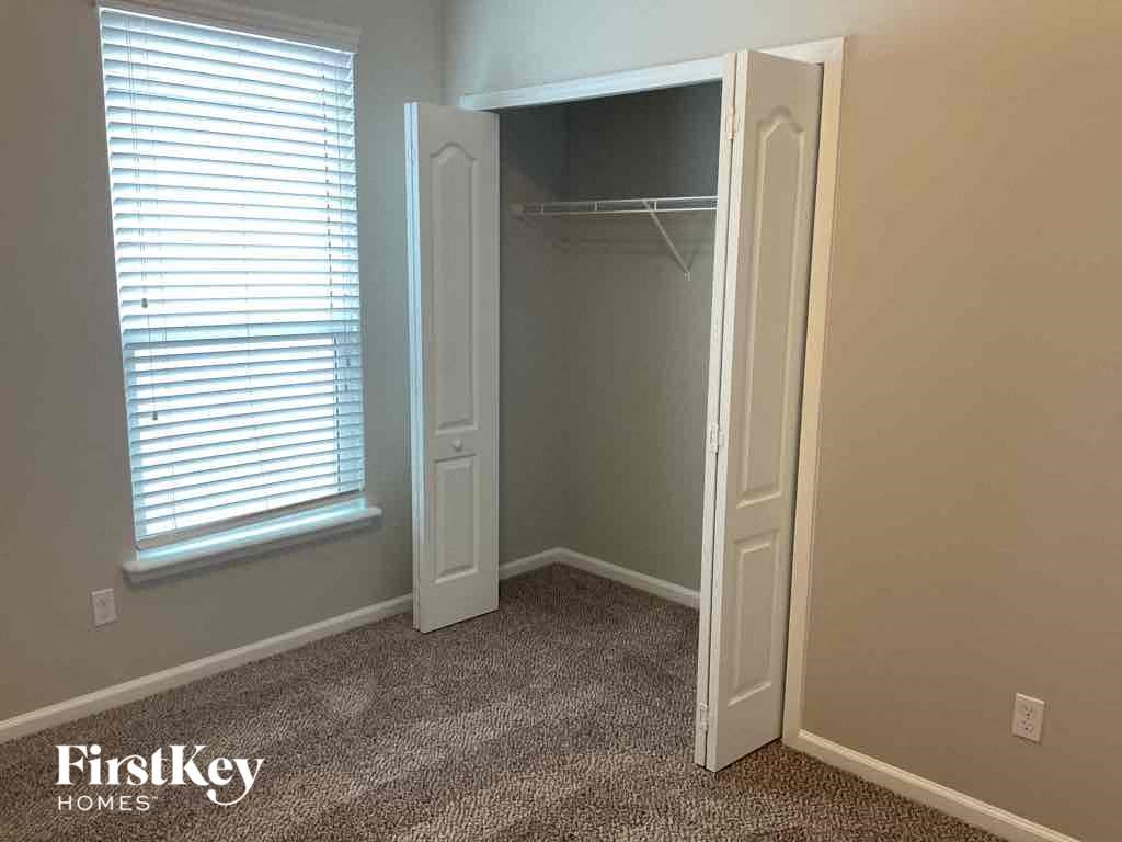 a closet in a room with a window and an open closet door