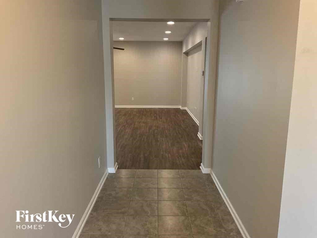 a hallway with a carpeted floor and a door to a closet