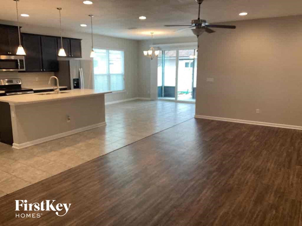 an empty kitchen and living room with wood flooring