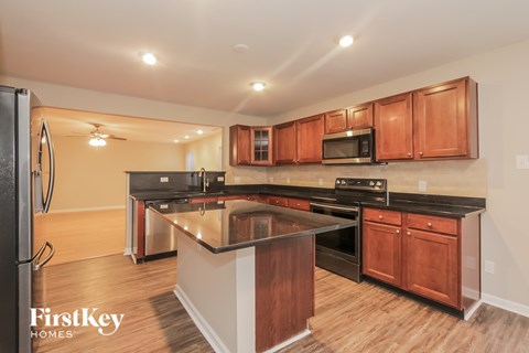 A kitchen with wooden cabinets and a black countertop.