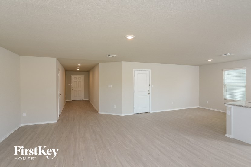 a spacious living room with wood floors and white walls