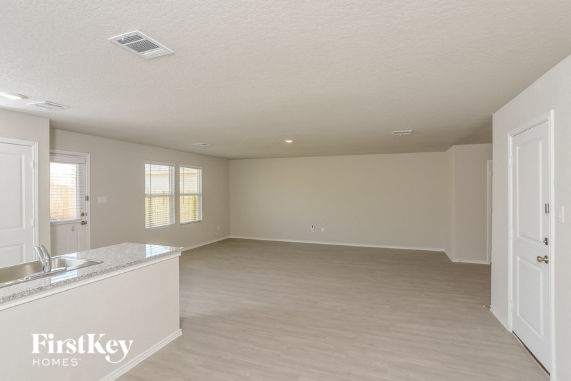 an empty kitchen and living room with a sink and a window