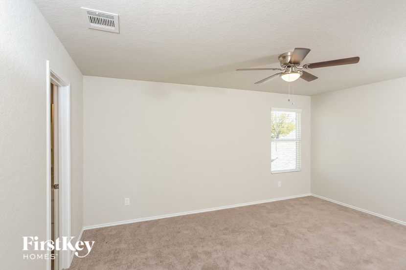 a bedroom with a ceiling fan and a window