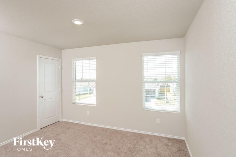 a bedroom with a carpeted floor and two windows