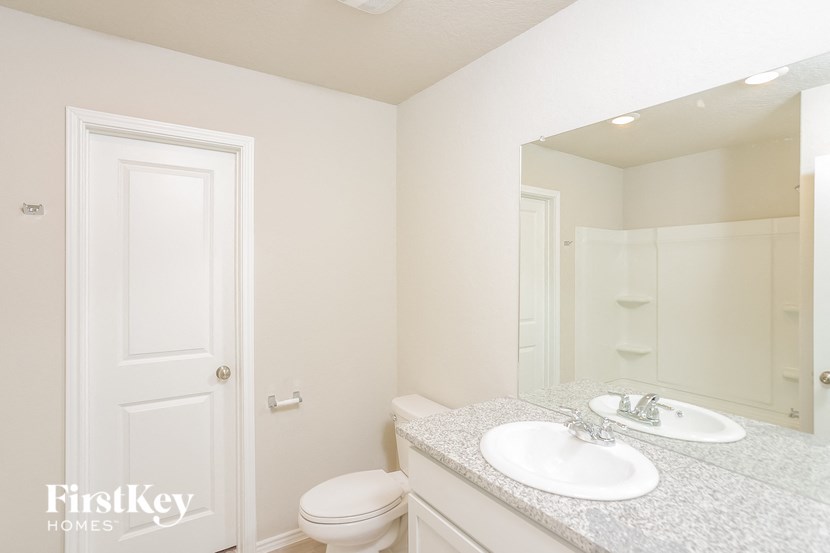 a white bathroom with a sink and toilet and a mirror