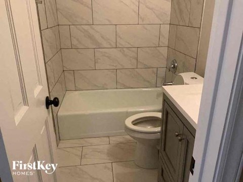 a bathroom with a toilet and a tub and a sink