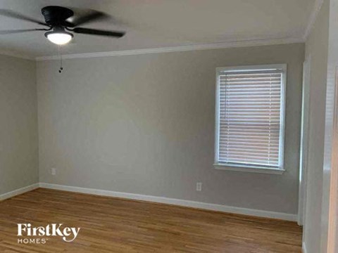 an empty room with a ceiling fan and a window