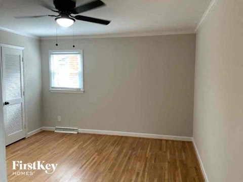 an empty room with a ceiling fan and wood floors