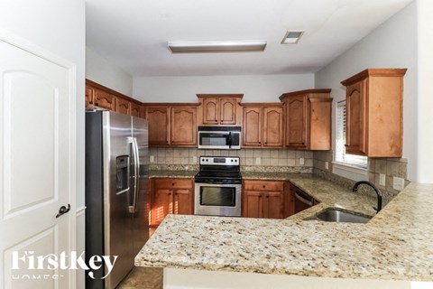 A kitchen with wooden cabinets and granite countertops.