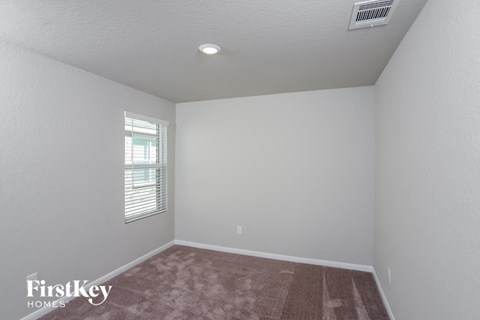 a bedroom with a carpeted floor and a window