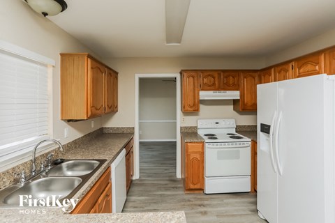 a kitchen with white appliances and wooden cabinets