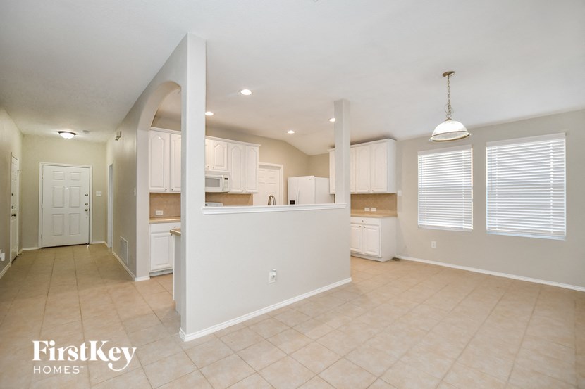 A spacious kitchen and living room with a white color scheme.