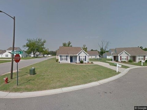 A stop sign is on the corner of a street.