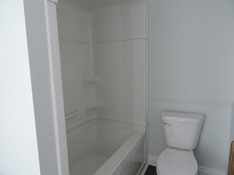 a small bathroom with a toilet and a bath tub