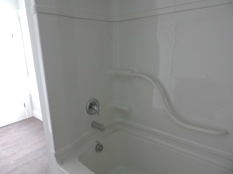 a white bath tub in a bathroom with white walls