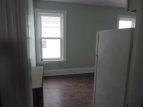 a small room with a refrigerator and a window