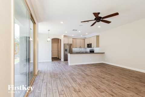 A spacious room with wooden flooring and a ceiling fan.