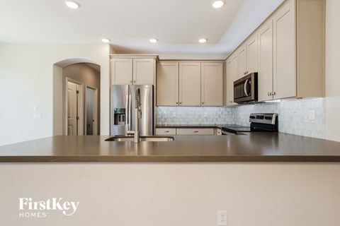 A kitchen with a black microwave on top of a counter.