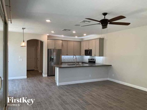 A spacious kitchen with a fan and a bar area.