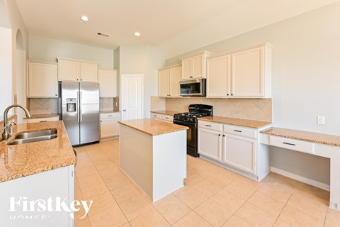 A kitchen with a granite counter top and stainless steel appliances.