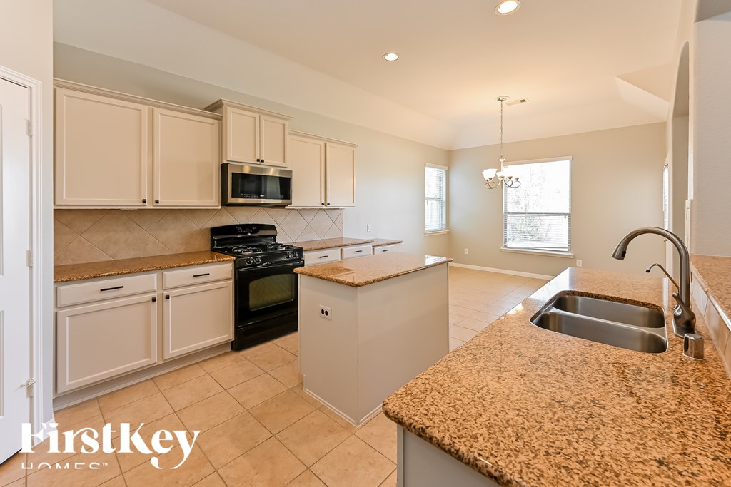 A kitchen with granite countertops and stainless steel appliances.