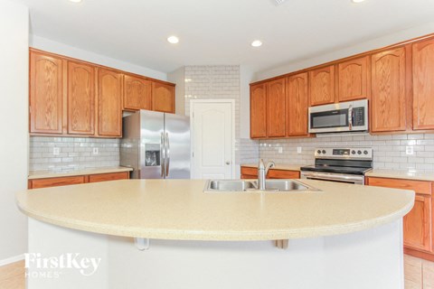 A kitchen with wooden cabinets and a white island.