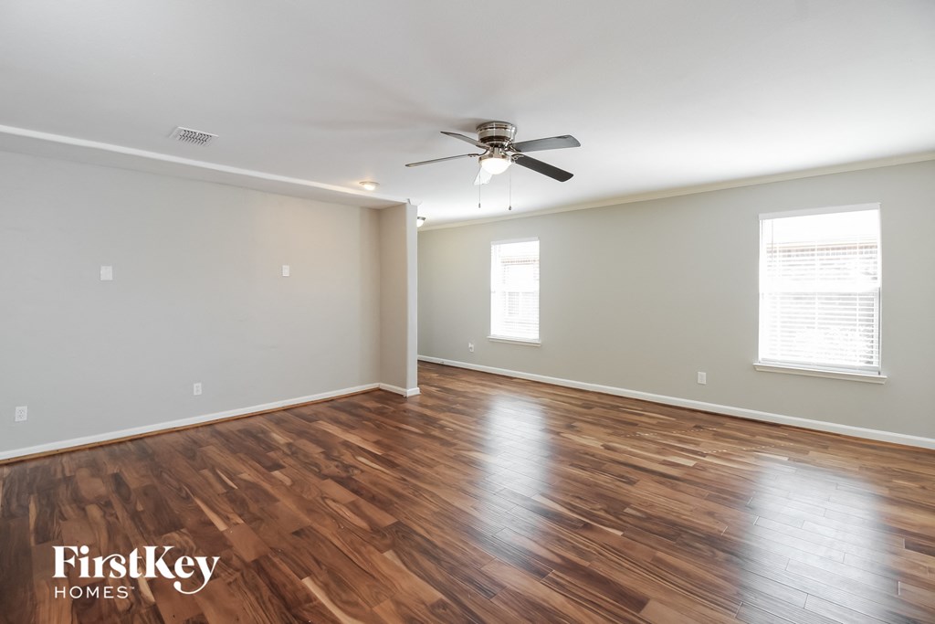 the living room with hardwood flooring and a ceiling fan