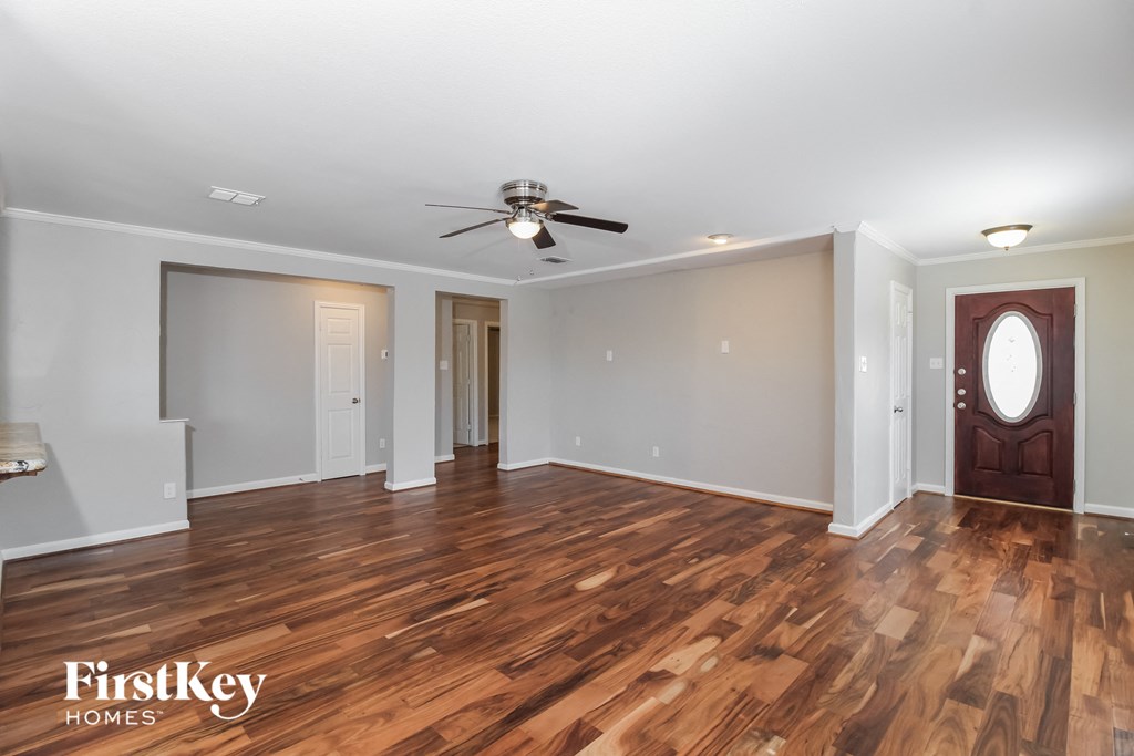 the living room with hardwood flooring and a ceiling fan