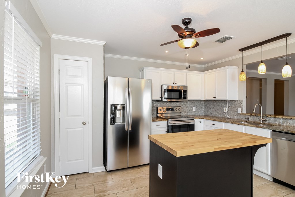 a kitchen with stainless steel appliances and a wooden island