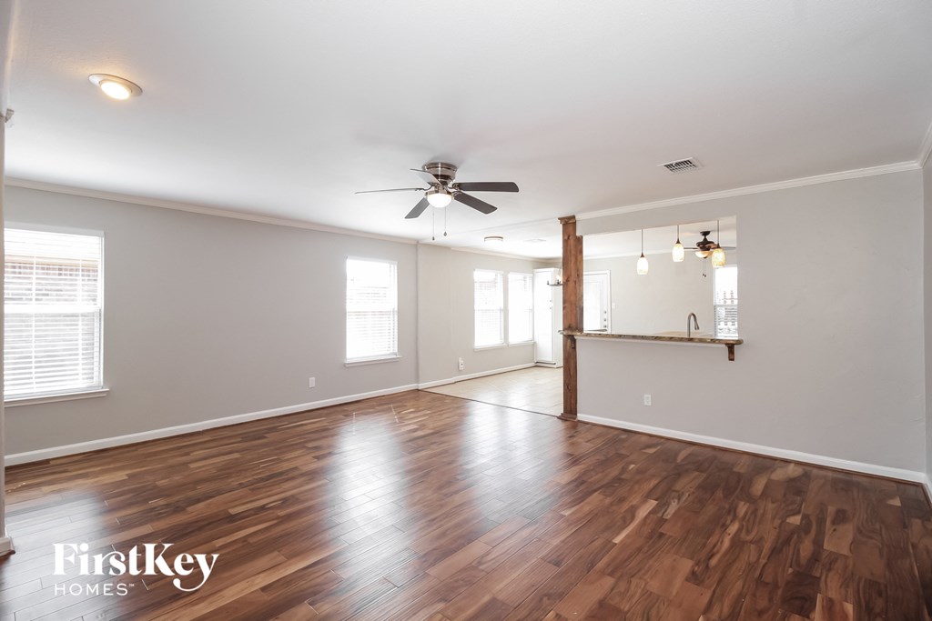 a living room with hardwood floors and a ceiling fan
