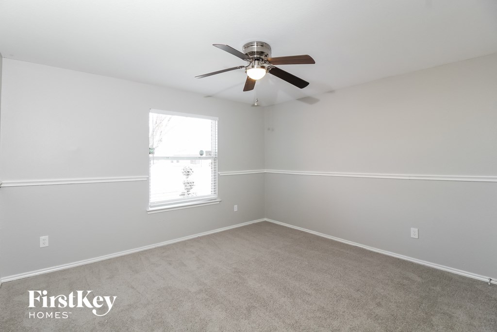 a bedroom with a ceiling fan and a window