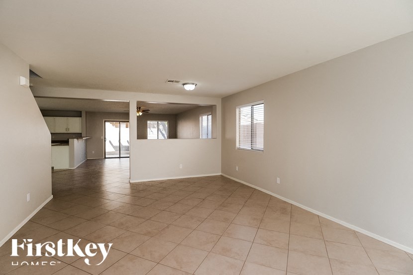 A spacious empty room with tiled flooring and a FirstKey Homes logo.