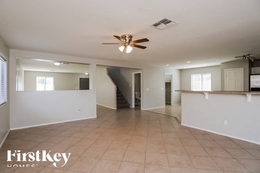 A spacious room with a fan and tiled flooring.