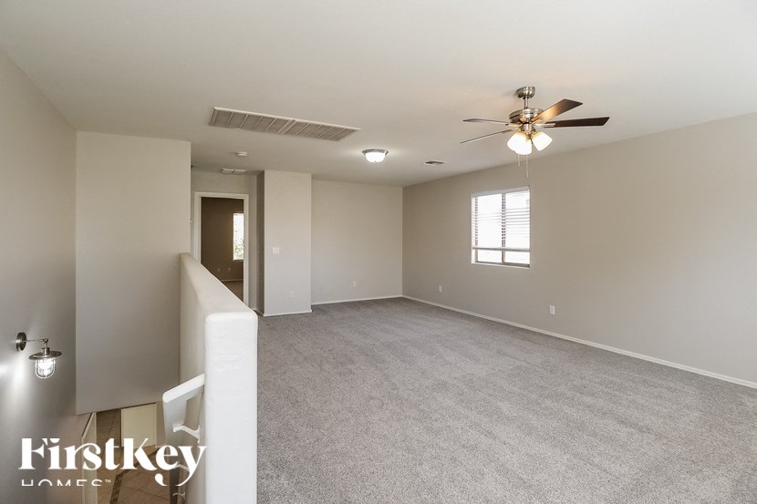 A spacious room with a ceiling fan and carpeted floor.