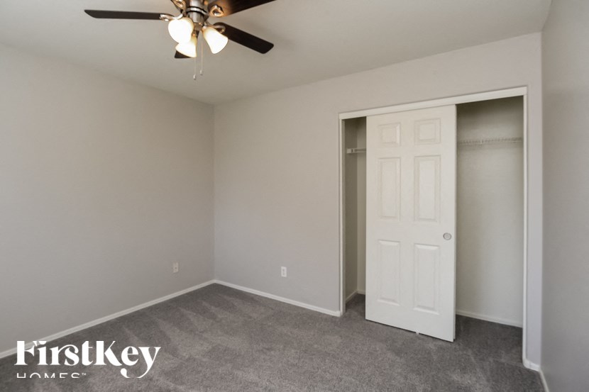 A room with a ceiling fan and a door.