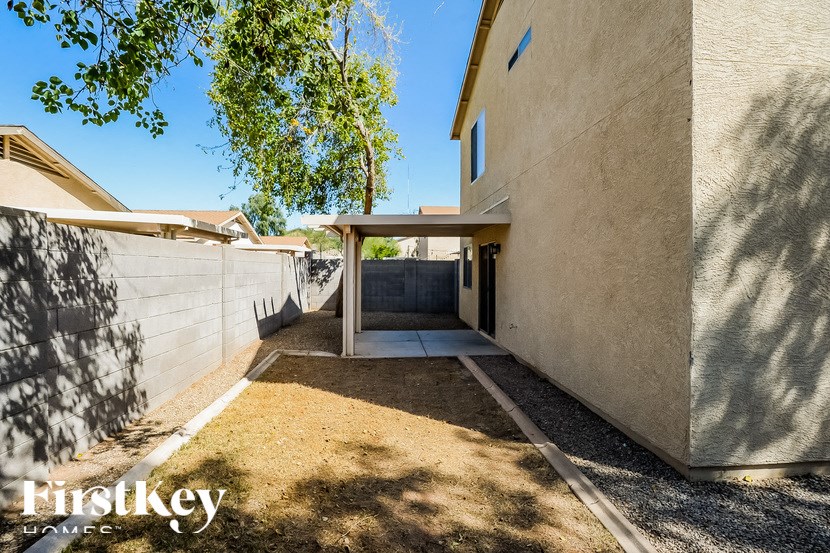 A modern house with a concrete exterior and a gravel driveway.