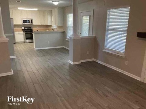 A kitchen with wooden floors and white cabinets.