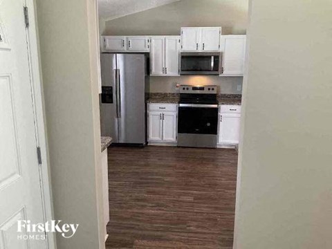 A kitchen with white cabinets and a stainless steel refrigerator.