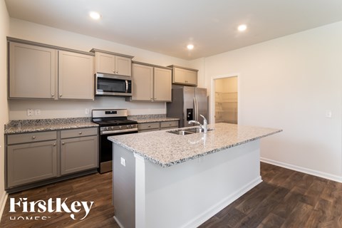 A kitchen with a granite countertop and a refrigerator.