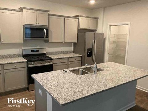 a kitchen with white cabinets and a granite counter top