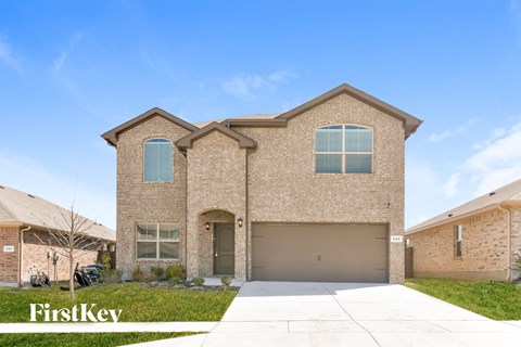 a house with a garage door in front of a lawn