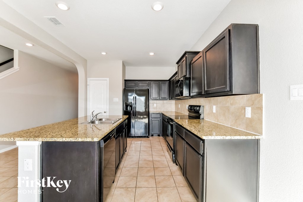 a kitchen with granite counter tops and black appliances