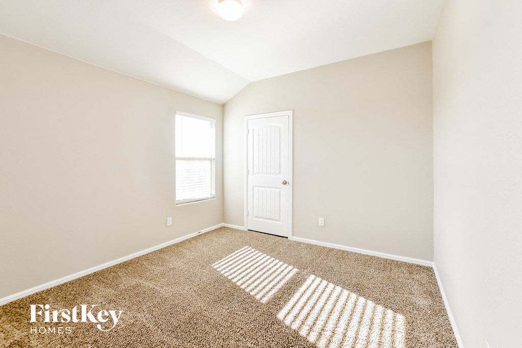a bedroom with a white door and a carpeted floor