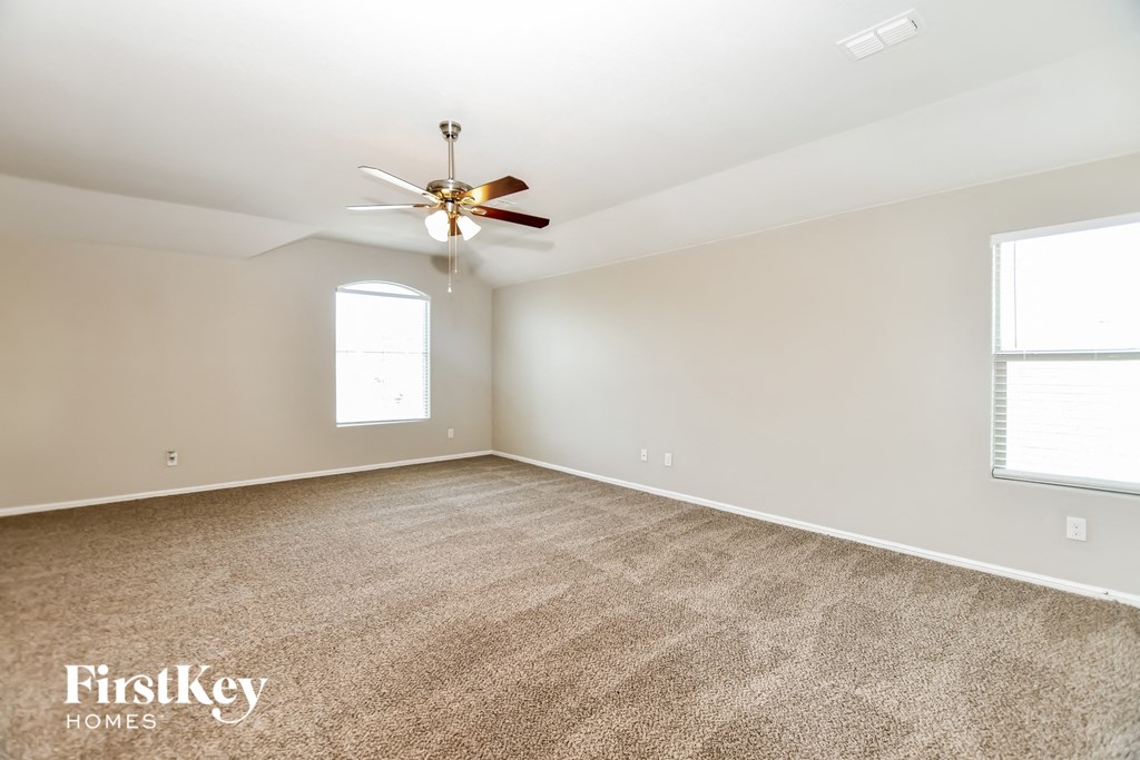 a living room with carpet and a ceiling fan