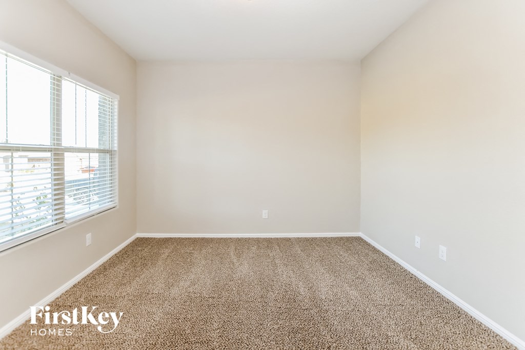 an empty room with carpet and a window