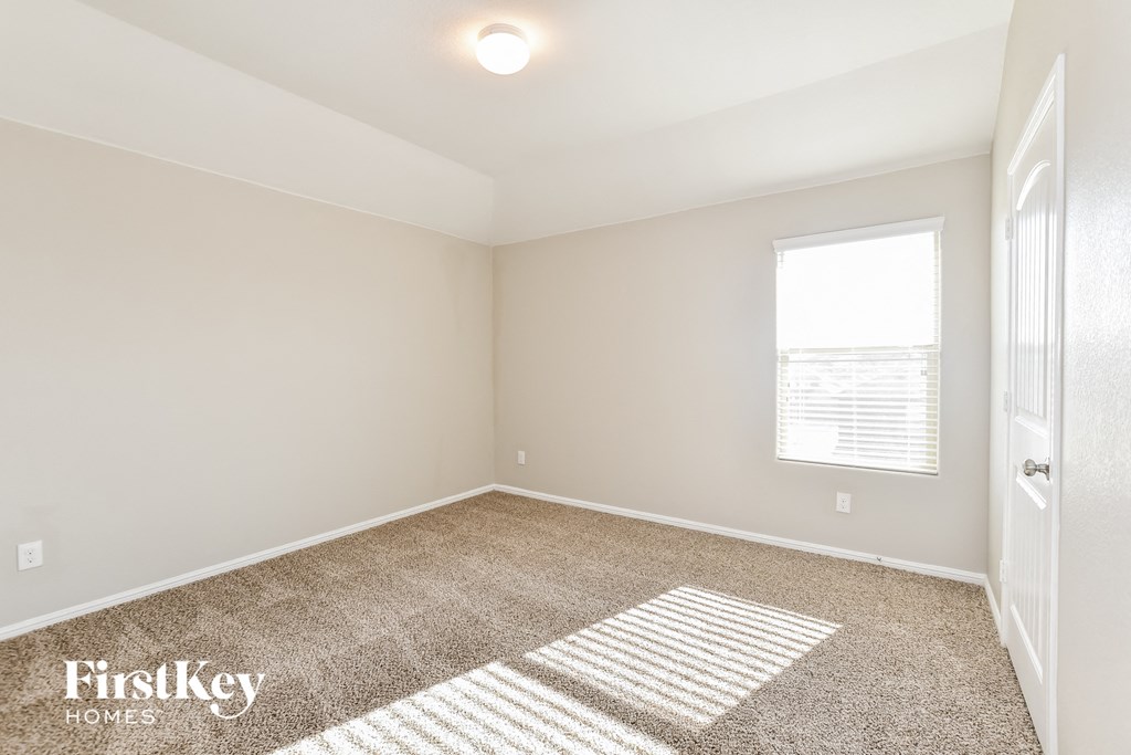 an empty room with carpet and a window