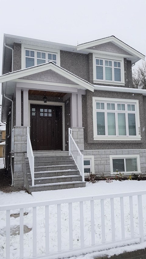 A house with a brown door and a white fence.