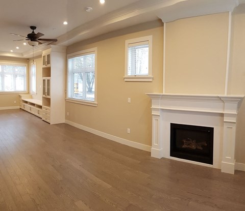 A living room with a fireplace and a ceiling fan.