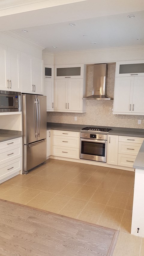 A kitchen with white cabinets and stainless steel appliances.