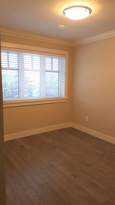 A room with a window and wooden flooring.
